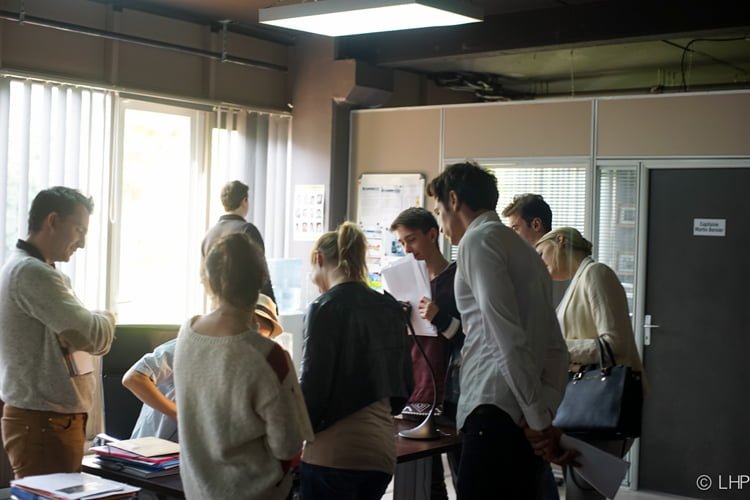 Nathan Ambrosioni (centre) meets with cast and crew while working on Therapy