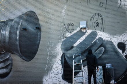 Mural artist DERKZ at work in the WIFF Alley